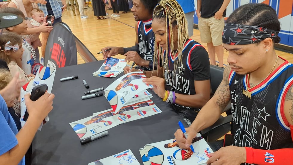 Globetrotters players Moose, Ace and Wham sign autographs at an event on Thursday.