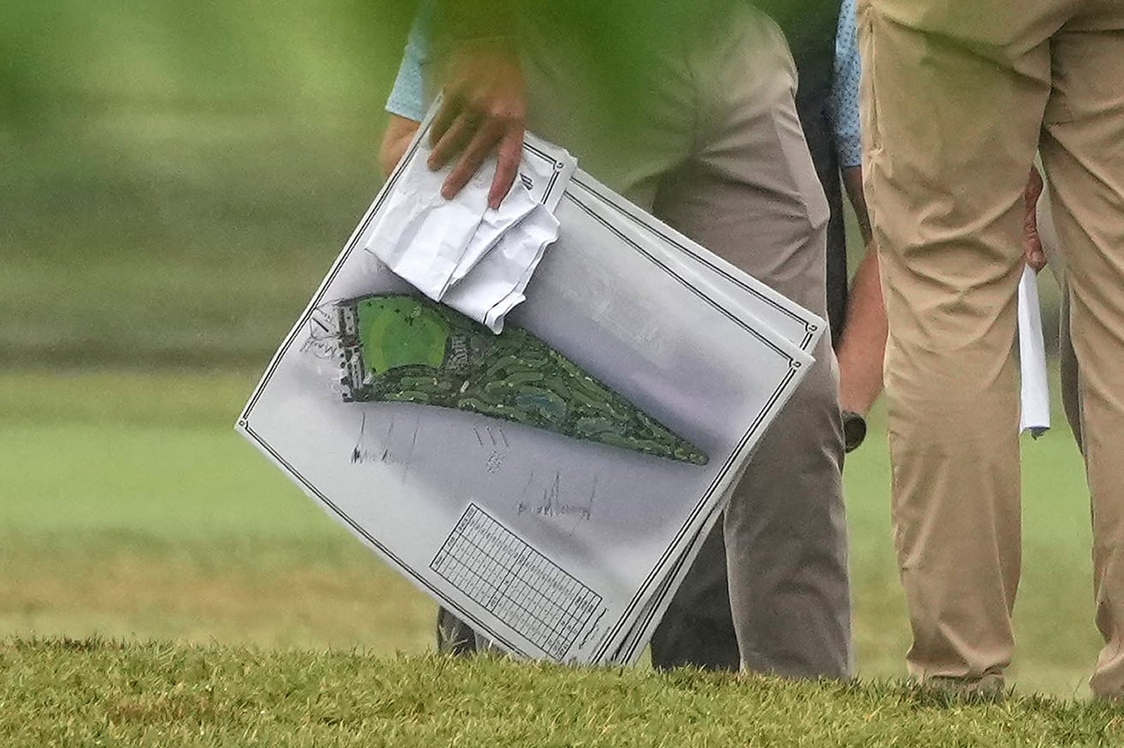 A person carries blueprints as President Donald Trump tours the East Potomac Park golf course,...