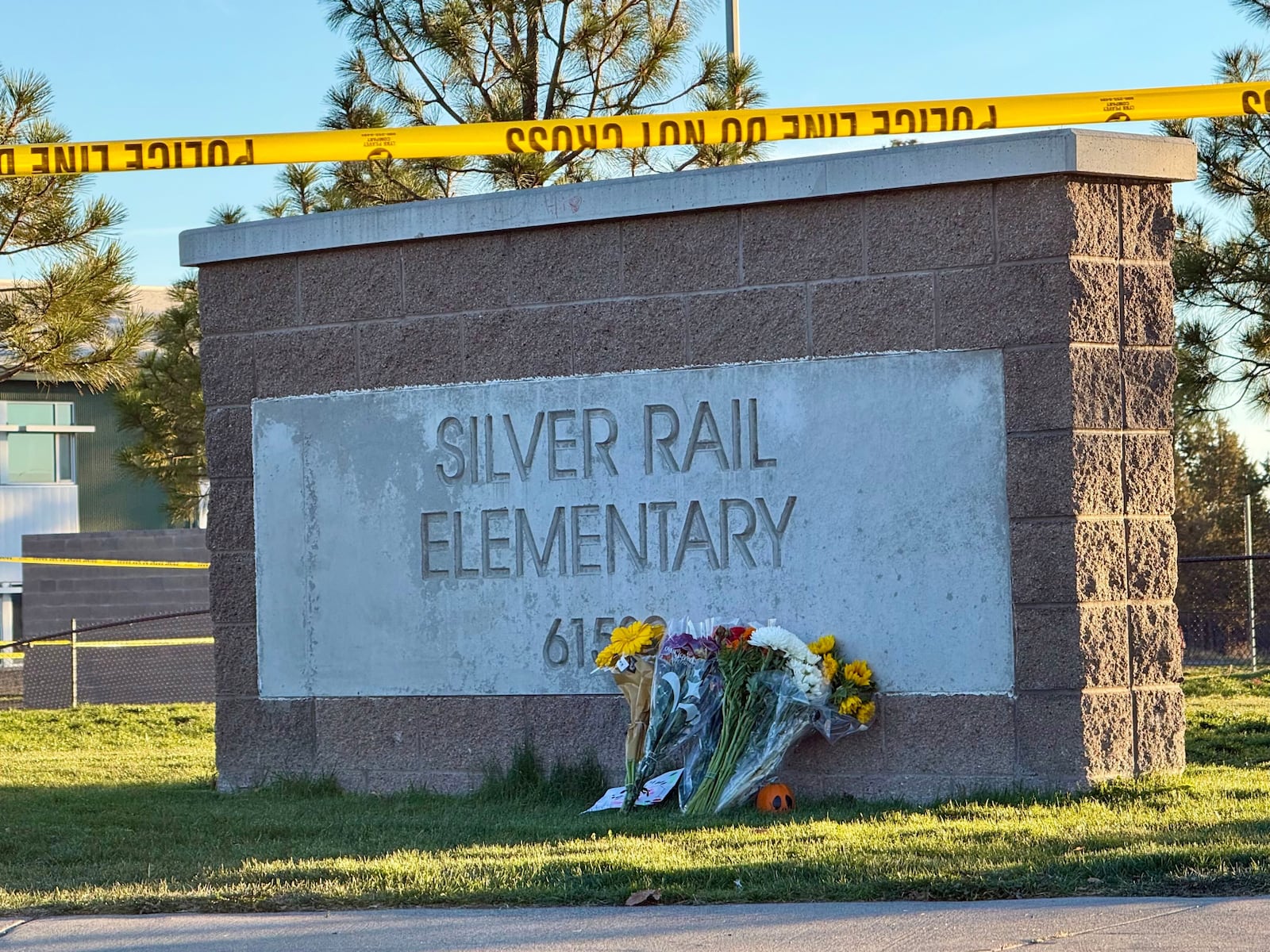 Flowers are placed beside a sign at Silver Rail Elementary School in Bend, Ore., on Friday,...