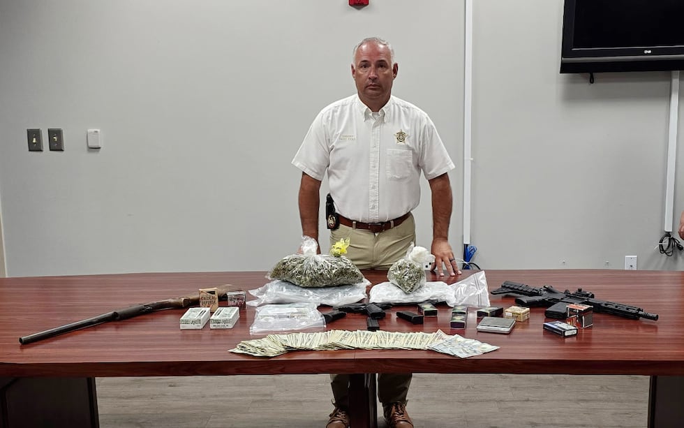 Sheriff Fred Cole stands next to seized items. The Warrant for Gorden's home resulted in...