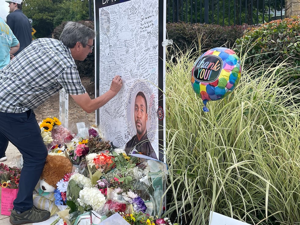 A well-wisher writes a message to Officer David Rose, who was killed last week exchanging...