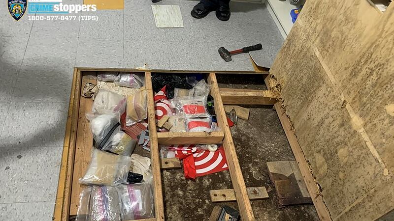 In this photo provided by the New York City Police Department, a trap door leans open over...