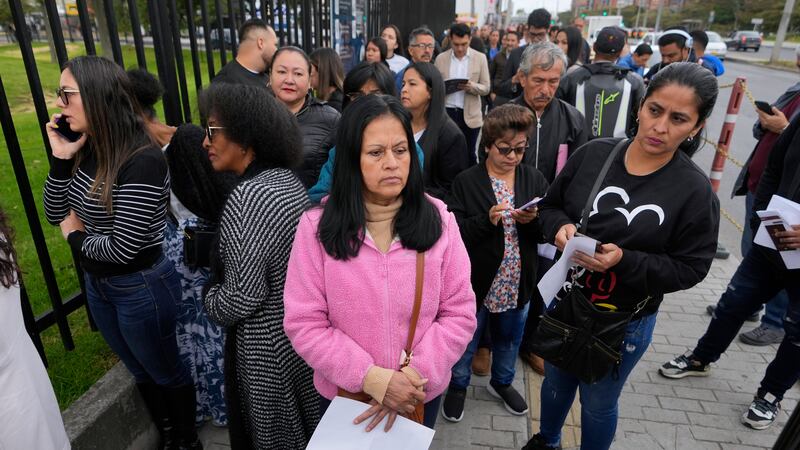 Gloria Camacho holds a notification stating her visa appointment was canceled, due to...