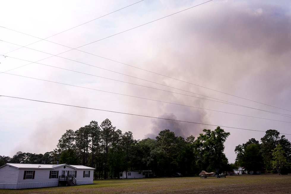 The Pineland road fire in Brantley, county burns behind homes, Wednesday, April 22, 2026, near...