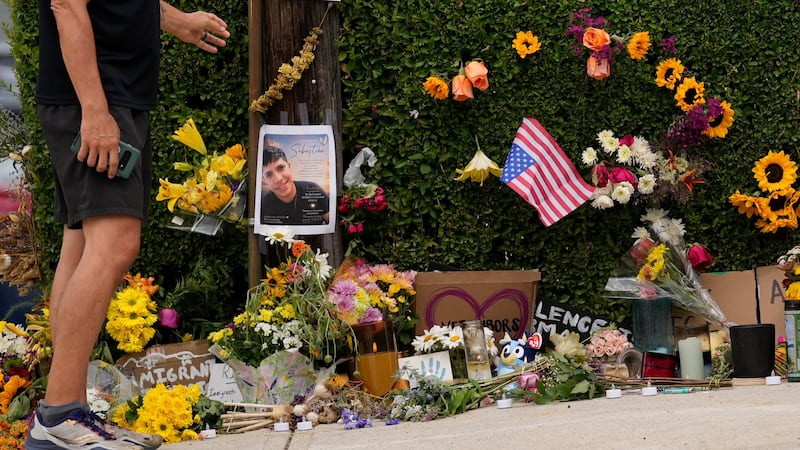 A man pauses to view a makeshift memorial to the victim of a shooting involving U.S....