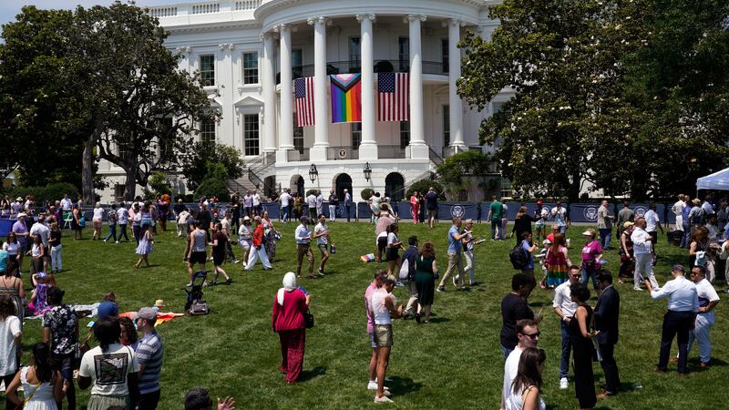 People walk on the South Lawn of the White House during a Pride Month celebration Saturday,...