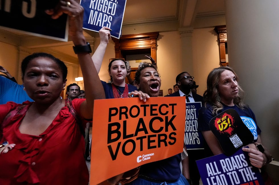 People listen and cheer as lawmakers speak about redistricting during a special legislative...