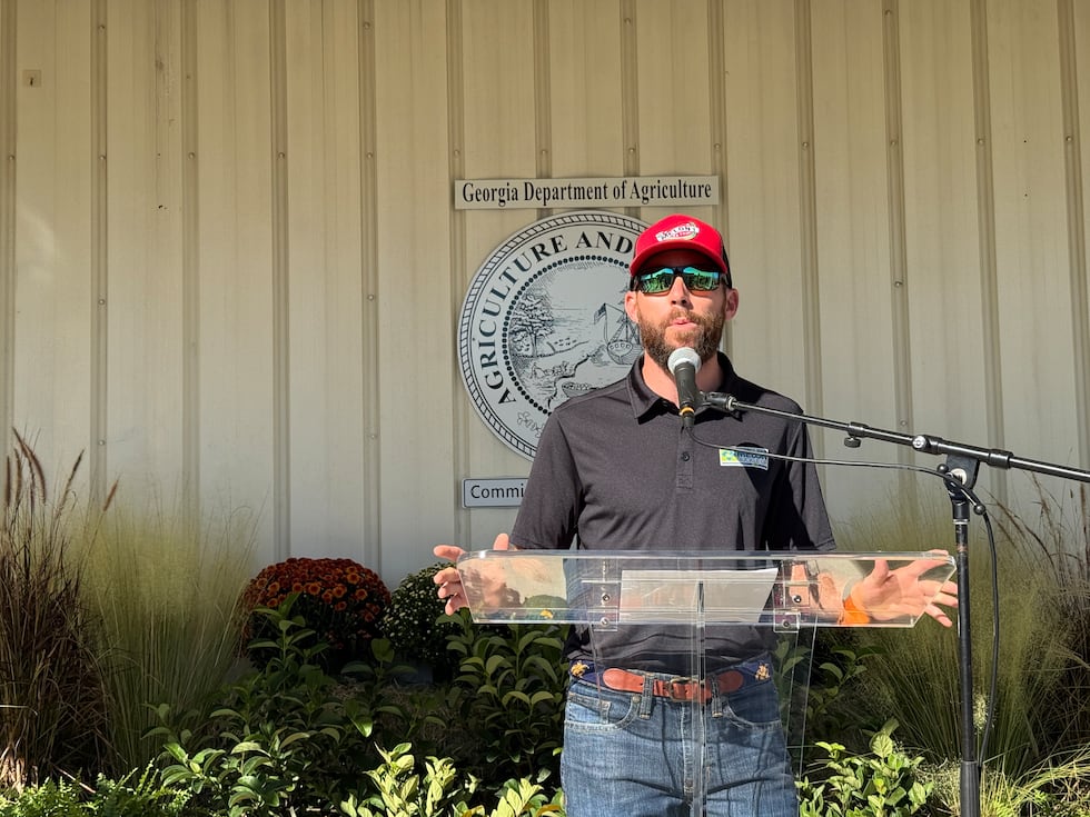 Commissioner Tyler J. Harper, Director Allen Poole, and NASCAR driver Ross Chastain hold a...