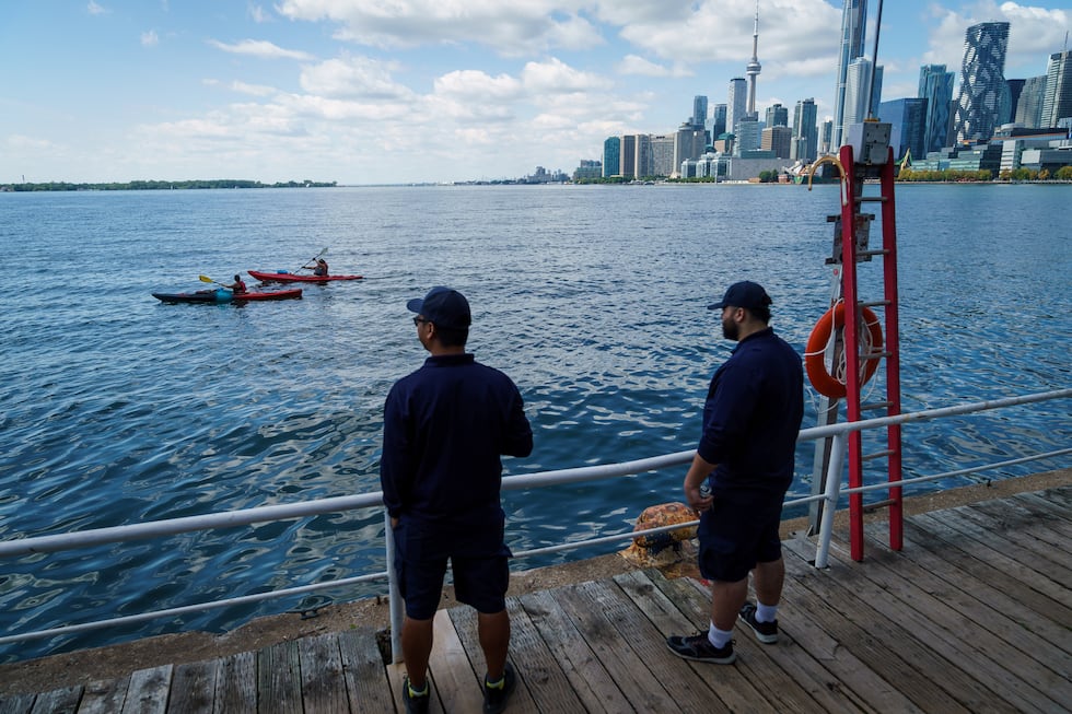 People look out across Lake Ontario from the harbor in Toronto, Tuesday, Aug. 25, 2026.