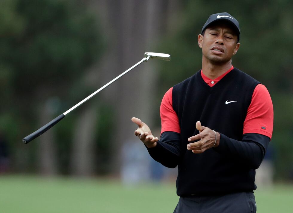 FILE - Tiger Woods flips his club after his shot to the 10th green during the final round of...