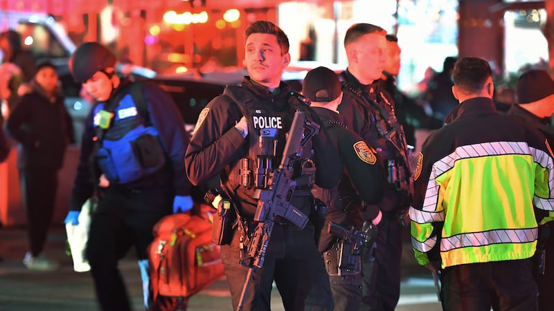 Law enforcement officials carrying weapons gather near Brown University in Providence, R.I.,...
