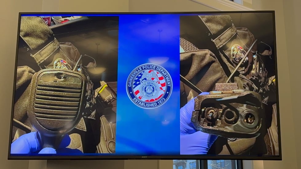 The photo shows the officer's radio and vest that are credited with stopping the bullet and...